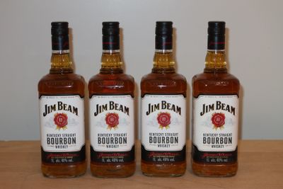 quatre bouteilles de bourbon Jim Beam posées sur une table