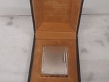 a small box with a silver coin in it on a marble surface
