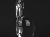 a clear glass vase with a curved handle on a black surface