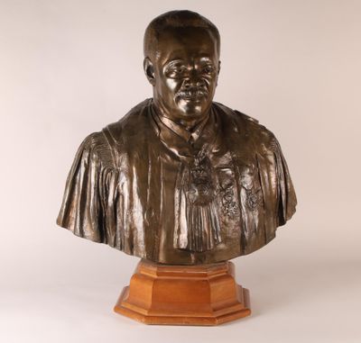 un buste en bronze représentant un homme vêtu d'une chemise et d'une cravate