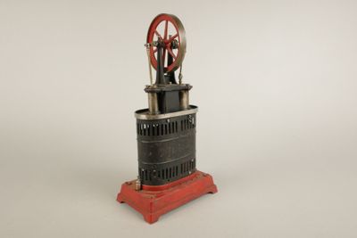 une petite machine rouge et noire posée sur une surface blanche