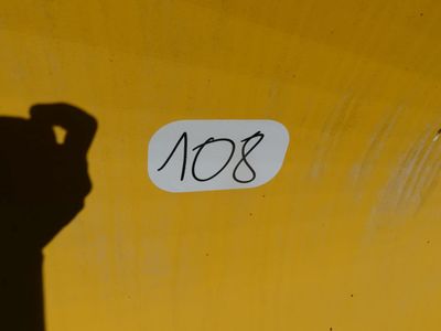 a sign that says no8 on the side of a yellow wall