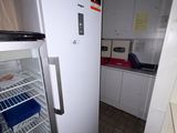 un réfrigérateur blanc dans une petite cuisine équipée d'un plan de travail