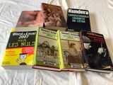 several books on a bed with a white sheet and white sheets
