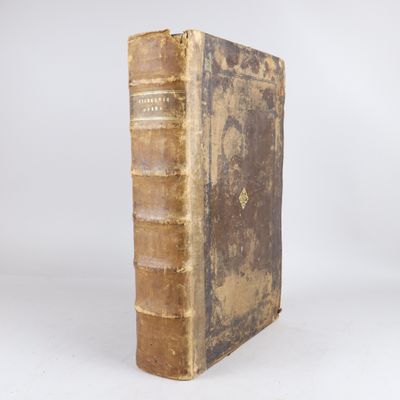un vieux livre posé sur une surface blanche