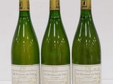 three bottles of wine are lined up on a white surface