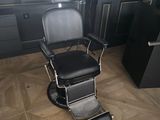 a black barber chair in a room with black walls