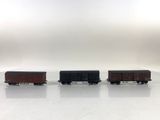 three train cars sitting side by side on a white surface