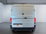 the back of a white van parked inside of a building
