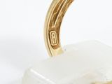 an image of a gold ring with a diamond on top of a rock