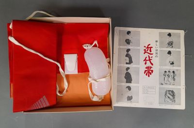 une boîte rouge avec un tissu rouge et un livre rouge
