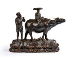 statue en bronze représentant un homme chevauchant une vache, avec un autre homme debout à côté