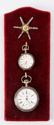 three different types of pocket watches displayed in a display case