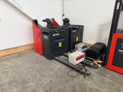deux chariots élévateurs garés l'un à côté de l'autre dans un garage