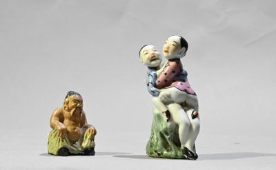 deux figurines représentant un homme et une femme assis sur une souche d'arbre