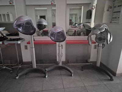 trois sèche-cheveux posés sur une table dans une pièce