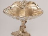 an antique silver plate with a bird on it and a bird on the base