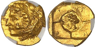 a close up of two gold coins on a white surface