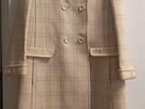 beige coat hanging on a wall in a room with a door