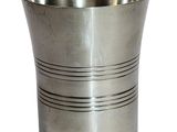 une tasse en argent posée sur une surface blanche