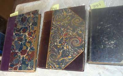 several old books are lined up on a table with tags on them