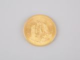 a gold coin on a white surface with a white background