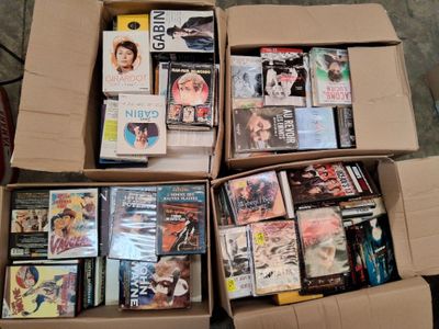 un grand nombre de dvd dans une boîte posée sur le sol