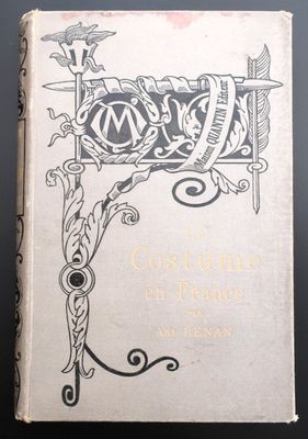 un vieux livre posé sur une table à côté d'une table noire