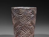 a close up of a cup on a table with a black background