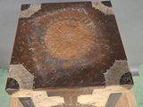 a small wooden box with a metal base on a table