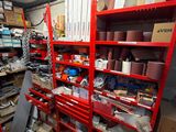 a red shelving filled with lots of items in a room