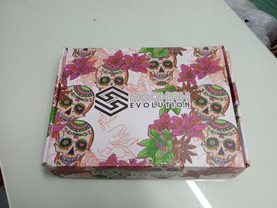 the box is open on a table with flowers and skulls on it