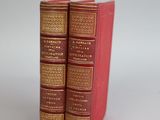 two red books sitting on top of each other on a table