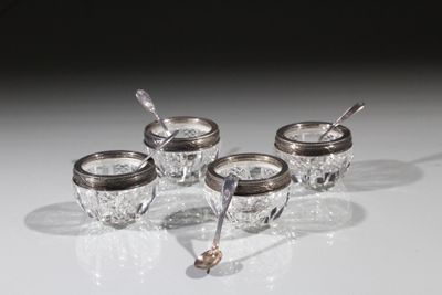 quatre tasses plaquées argent avec leurs cuillères, posées sur un fond blanc