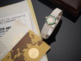 une montre posée sur une table, à côté d'une feuille de papier