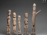 a group of four carved wooden figures of people