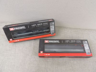 two boxes of black and red electronic devices sitting on a couch