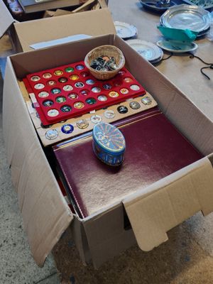 une boîte contenant des boutons et d'autres objets, posée sur une table