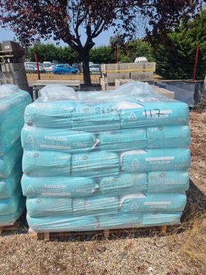 many bags of water sitting on pallets on the ground