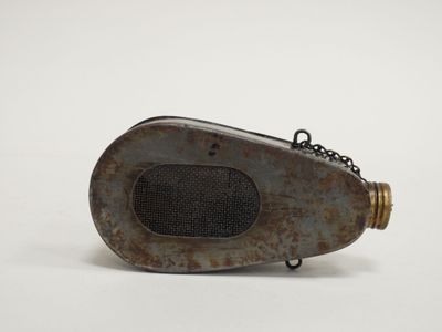 un vieil objet métallique entouré d'une chaîne, posé sur une surface blanche