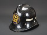 an old black fireman ' s helmet with a lion emblem on it