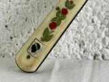 a knife with a rose design on it sitting on a table