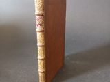 an old book sitting on top of a table next to a gray wall