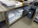 stainless steel table with bins on top of it in a kitchen