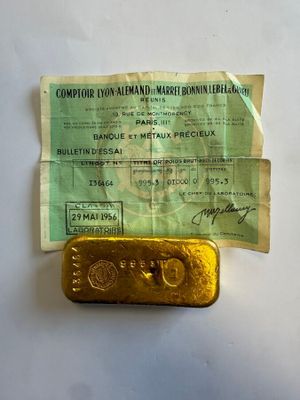 un vieux lingot d'or posé sur une feuille de papier
