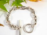 silver chain bracelet with a cross charm on a white background