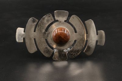 une image représentant un bracelet en argent orné d'une pierre marron au centre