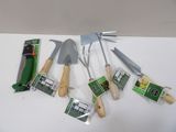 cinq types différents d'outils de jardinage posés sur une table