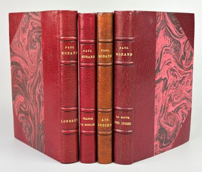 three red books are stacked on top of each other on a white surface