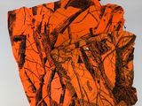 a pile of orange camouflage shirts on a white surface